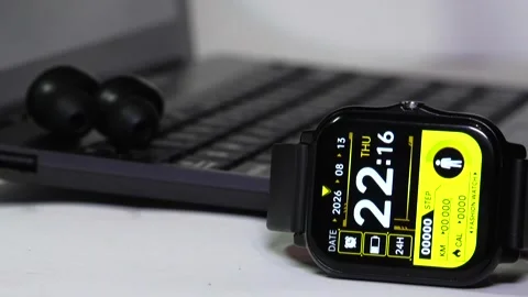 Rack focus from a white background and computer to a smartwatch Stock Footage 342257588