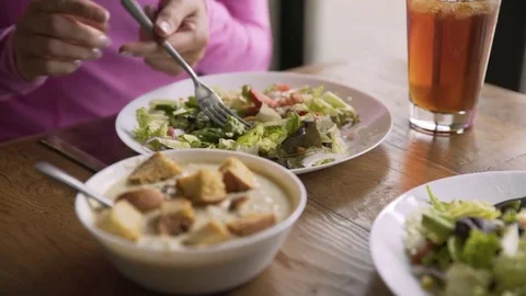 Rack focus of woman having lunch at table in restaurant Stock Footage