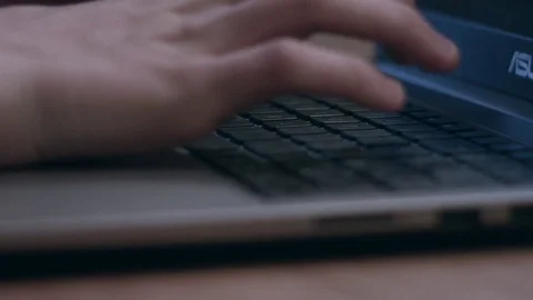 Rack focus of young man typing on laptop keyboard Stock Footage 75276811