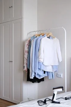 Rack with hanging clothes in the interior of the dressing room. Stock Photos