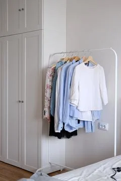 Rack with hanging clothes in the interior of the dressing room. Stock Photos