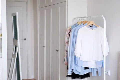 Rack with hanging clothes in the interior of the dressing room. Stock Photos