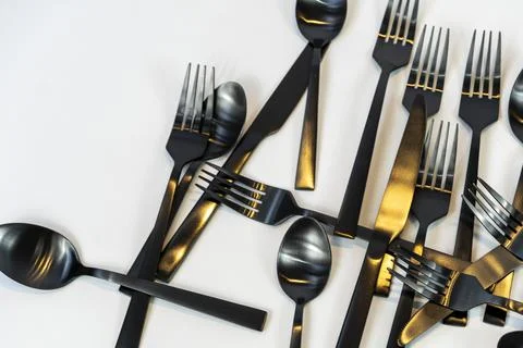 Rack of kitchen utensils, isolated on white. Stainless steel with black handles Stock Photos