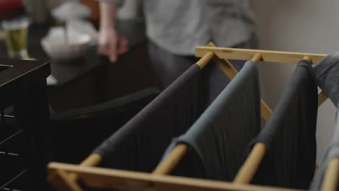 Rack of laundry to a man talking on his smartphone in his home office 動画素材 133296610