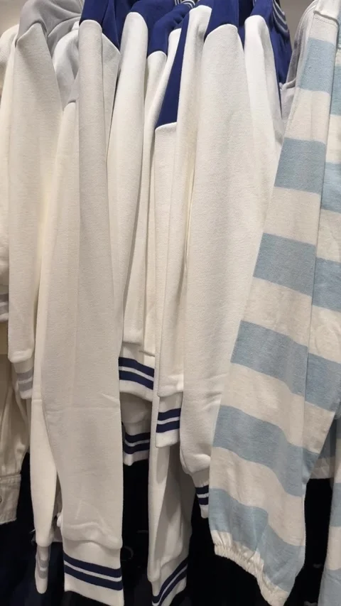 A rack of light blue and white striped sweaters 스톡 동영상 321340597