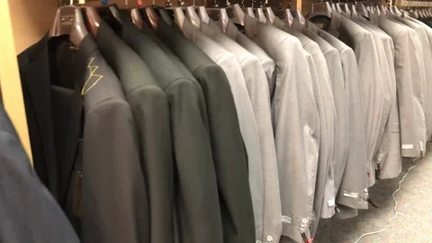 Rack of same color suits on rack move Stock Footage 98590445