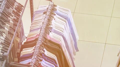A rack of shirts is on display in a store Stock Photos