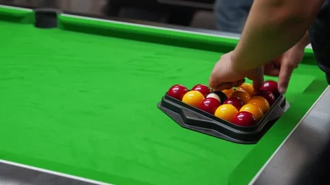 Racking balls in triangle in blackball Pool game on a green cloth pool table Stock Footage 297808584