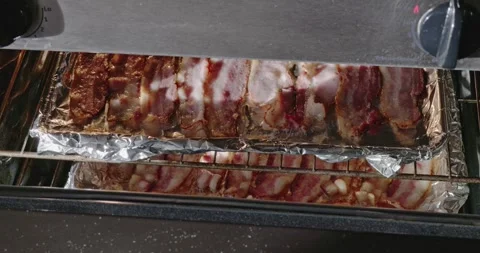 Racks of bacon with sunlight into oven Stock Footage 306260256