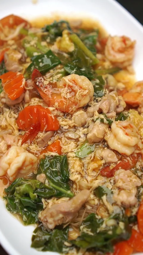 Rad Na Koong Kai, Thai noodles topped with thick savory gravy, prawns, and chick Stock-Footage 337536333