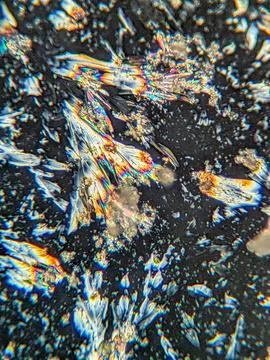 Radial crystal structures under polarized microscope with colorful edge Stock Photos