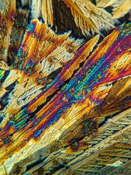 Radial crystal structures under polarized microscope with colorful edge Stock Photos