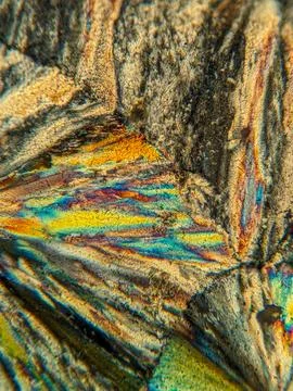 Radial crystal structures under polarized microscope with colorful edge Stock Photos