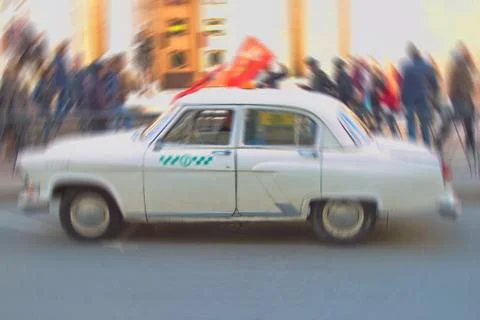 Radially blurred background image of a parked retro taxi during the festive Stock Photos