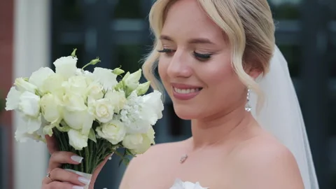 Radiant bride smiling with a white rose bouquet. A close-up of a radiant bride Stock Footage 284435247