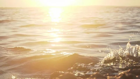 Radiant golden sunset casting warm glowing light across ocean waves Stock Footage 337416501