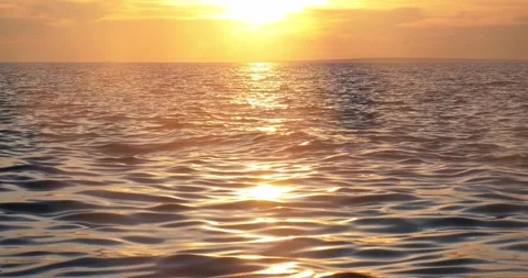 Radiant golden sunset light reflecting over calm open ocean waters Stock Footage 337409228