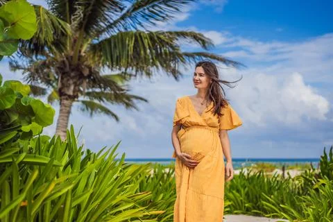 A radiant pregnant woman after 40 basking in the sun's warmth on a tropical Stock Photos