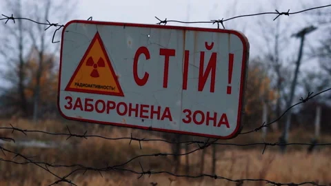 Radiation Warning Sign on a Barbed Wire Fence in Chernobyl Stockbeeldmateriaal 348100418