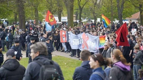 Radical left Antifa park protest, flags banners, police officer line, Berlin Stock Footage 87456128