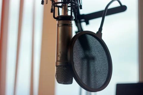 Radio broadcast setup with microphone and pop filter in a studio environmen.. 스톡 사진
