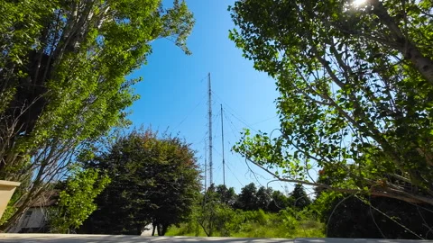 Radio Communication Antenna Tower in a Green Landscape Under Clear Blue Sky Video stock 342963402