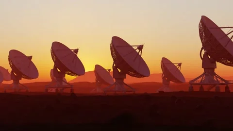 Radio telescope array silhouetted against a glowing desert sunset Vídeos de archivo 201098349