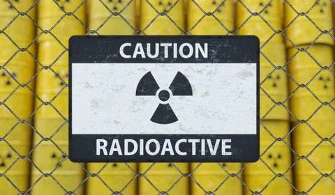 Radioactive caution sign on chain link fence and many barrels with nuclear wa Stock-Fotos