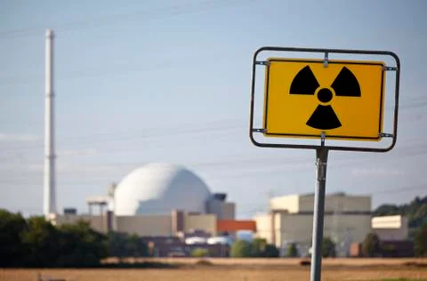 A radioactive warning sign in front of a nuclear power plant. Stock Photos