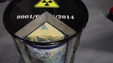 Radioactive waste barrel cut open to reveal layered contents of syringes gloves  Stock Footage 311130908