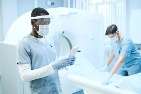 Radiographer using tablet in MRI room Stock Photos