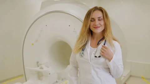 Radiologist against the background of a high-tech MRI machine in the clinic Stock Footage 238735711