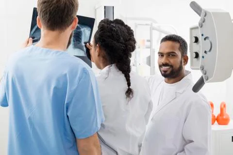 Radiologist With Colleagues Analyzing X-ray In Hospital Stock Photos