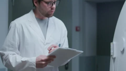 Radiologist Interviewing Female Patient Lying on CT Scanner Bed after Procedure Stock Footage 335255744