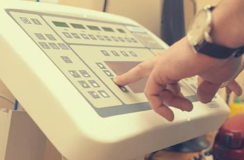 The radiologist presses the button of the control panel to produce an X-ray i Stock Photos