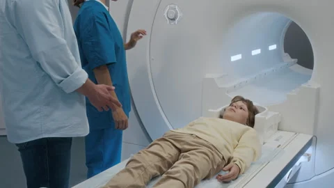 Radiologist Pressing Button on MRI Machine and Watching Patient Table Raising Stock Footage 318664990