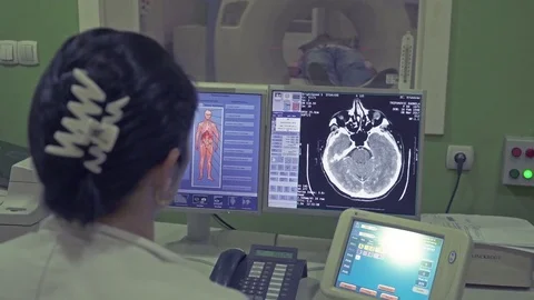Radiologist scanning patient, focus on monitor screen, crane shot Stock Footage