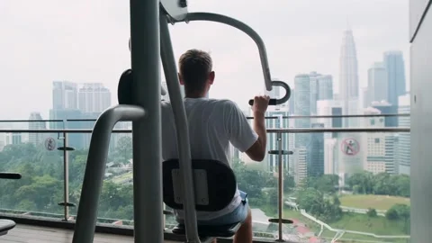 Raer view of man exercising on chest press fitness machine in outdoor gym on Stock-Footage 282923498