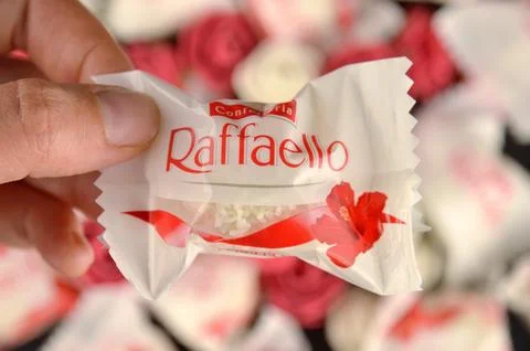 RAFFAELLO candy in a hand on a blurry background Stock Photos