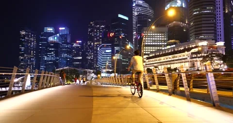 Raffles Place night view with cyclists at Esplanade Bridge Singapore Stock Footage 157393802