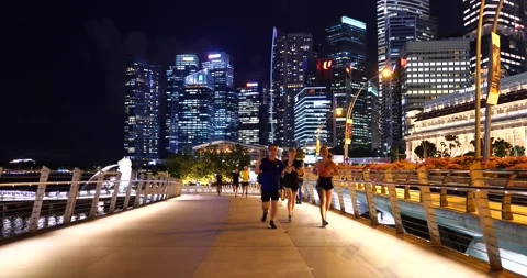 Raffles Place night view with walking people at Esplanade Bridge Singapore Stock Footage 157393720