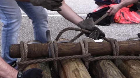 Raft Competition - Team pulling rope and fasten trunks building a Raft Video stock 64300315
