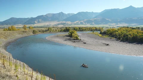 Raft floating down Yellowstone River in Autumn Light Stock Footage 317849081
