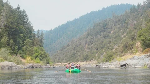 Raft with people floating down a river Stock Footage 103812831