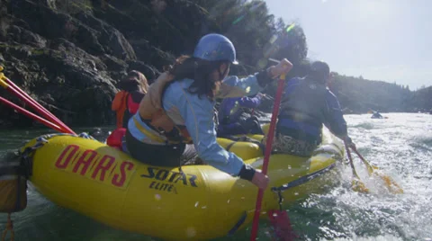 Rafters paddle and negotiate rapids on a fast flowing river. Stock Footage