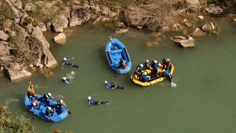 Rafting group, climbing on raft an floating on water  – view from above Stock Footage 98321432