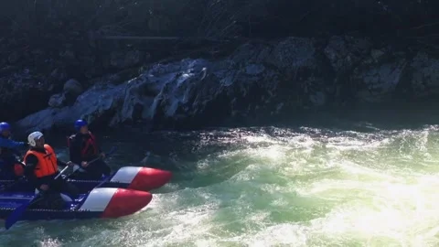 The rafting team descends the rough rapids in the mountain river with paddles. Stock-Footage 241025010