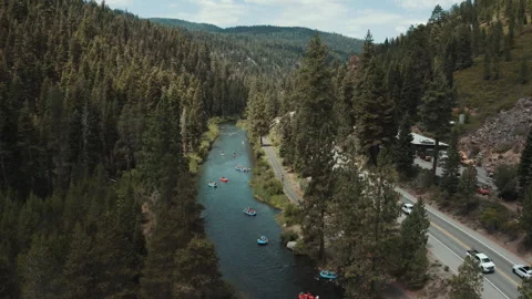 Rafts floating down the Truckee River beside a highway aerial Stock-Footage 348049557
