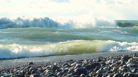 Raging elements, big waves hitting small rocks. Lots of spray and foam, blue sky Video stock 171099485