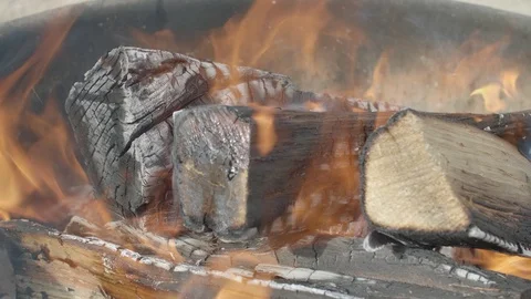 Raging hot orange fire turns charred camping wood into charred embers. Stock Footage 109480906